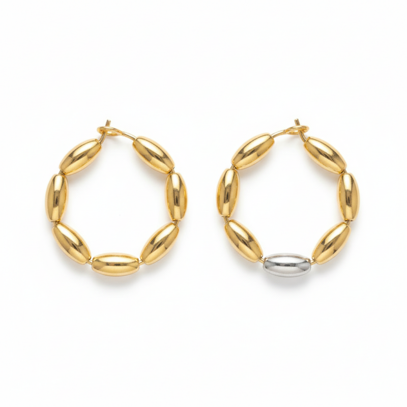 Two-tone gold and silver oval bead hoop earrings on white background