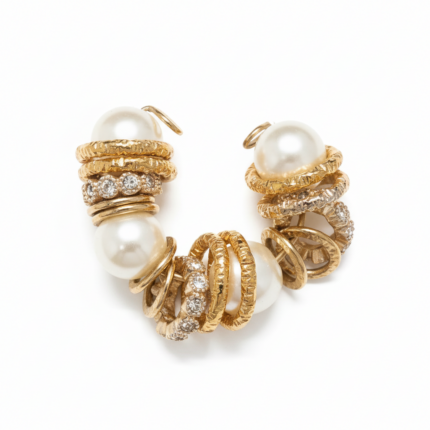 Pearl and gold caged crystal bracelet with textured gold-tone rings and pavé accents on white background