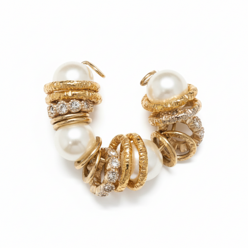 Pearl and gold caged crystal bracelet with textured gold-tone rings and pavé accents on white background