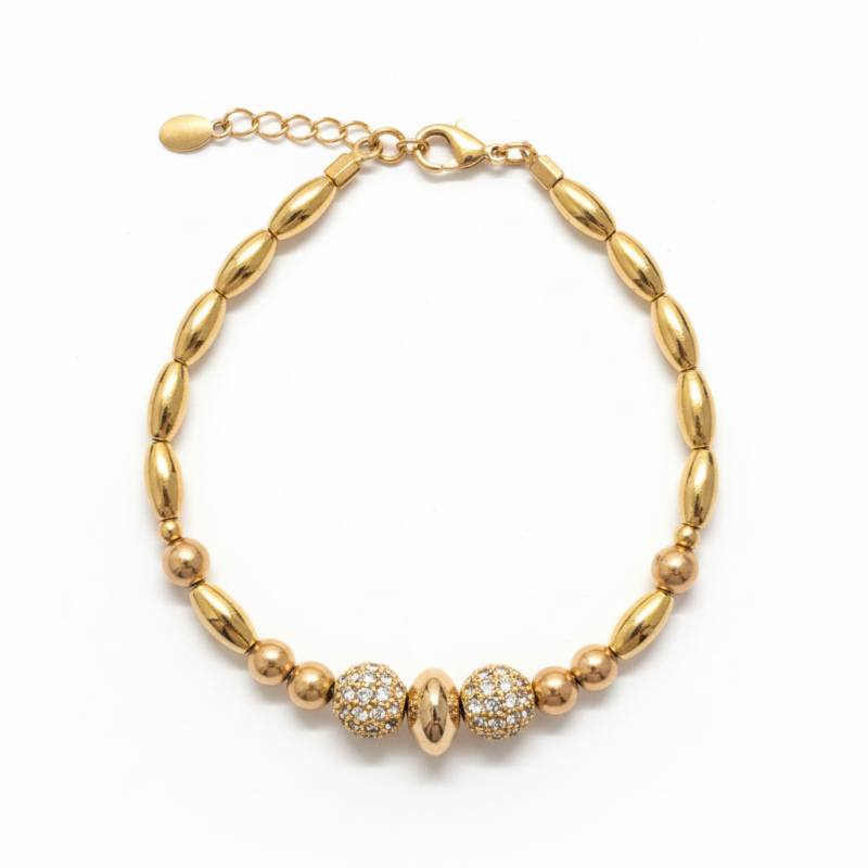 Gold-tone pavé crystal beaded bracelet with oval beads and lobster clasp on white background